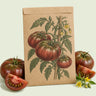 Kraft seed packet illustrated with Black Krim Pole Tomato, with fresh Black Krim Pole Tomato beside it