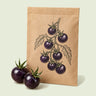 Kraft seed packet illustrated with Black Pearl Cherry Tomato, with fresh Black Pearl Cherry Tomato beside it