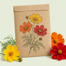 Kraft seed packet illustrated with Bright Lights Blend Cosmos, with fresh Bright Lights Blend Cosmos beside it