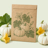 Kraft seed packet illustrated with Casperita Pumpkin, with fresh Casperita Pumpkin beside it