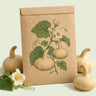 Kraft seed packet illustrated with Corsican Hard-Shelled Gourd, with fresh Corsican Hard-Shelled Gourd beside it