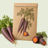 Kraft seed packet illustrated with Cosmic Purple Carrot, with fresh Cosmic Purple Carrot beside it