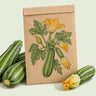 Kraft seed packet illustrated with Costata Romanesco Summer Squash, with fresh Costata Romanesco Summer Squash beside it