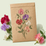 Kraft seed packet illustrated with Early Multiflora Blend Sweet Pea, with fresh Early Multiflora Blend Sweet Pea beside it
