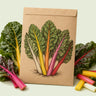 Kraft seed packet illustrated with Five Color Silverbeet Swiss Chard, with fresh Five Color Silverbeet Swiss Chard beside it