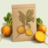 Kraft seed packet illustrated with Golden Boy Beet, with fresh Golden Boy Beet beside it