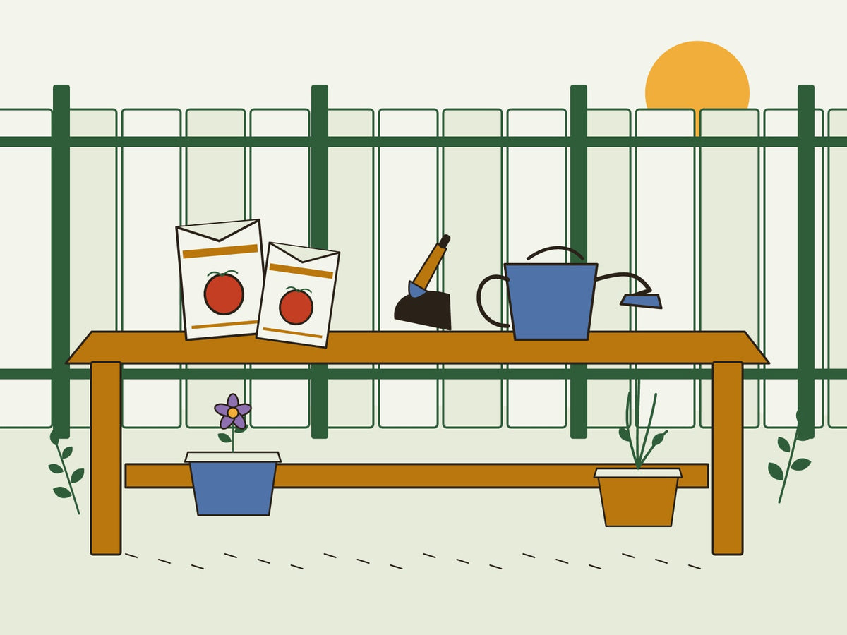 Seed packets, a watering can, and potted plants on a potting bench beside a neighbor's fence.