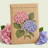 Kraft seed packet illustrated with Hydrangea, with fresh Hydrangea beside it