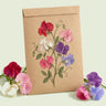 Kraft seed packet illustrated with Little Sweetheart Dwarf Sweet Pea, with fresh Little Sweetheart Dwarf Sweet Pea beside it