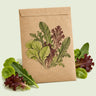 Kraft seed packet illustrated with Market Day Mesclun Lettuce Mix, with fresh Market Day Mesclun Lettuce Mix beside it