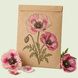 Kraft seed packet illustrated with Pandora Poppy, with fresh Pandora Poppy beside it