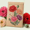 Kraft seed packet illustrated with Peony Double Poppy Blend, with fresh Peony Double Poppy Blend beside it