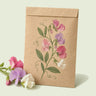 Kraft seed packet illustrated with Perennial Sweet Pea Blend, with fresh Perennial Sweet Pea Blend beside it