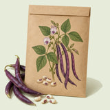 Kraft seed packet illustrated with Pinkeye Purple Hull Cowpea, with fresh Pinkeye Purple Hull Cowpea beside it