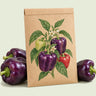 Kraft seed packet illustrated with Purple Beauty Sweet Pepper, with fresh Purple Beauty Sweet Pepper beside it