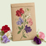 Kraft seed packet illustrated with Royal Sweet Pea Blend, with fresh Royal Sweet Pea Blend beside it