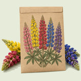Kraft seed packet illustrated with Russell Lupine Blend, with fresh Russell Lupine Blend beside it