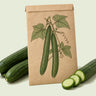 Kraft seed packet illustrated with Telegraph Improved Long Cucumber, with fresh Telegraph Improved Long Cucumber beside it