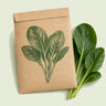 Kraft seed packet illustrated with Tendergreen Komatsuna, with fresh Tendergreen Komatsuna beside it