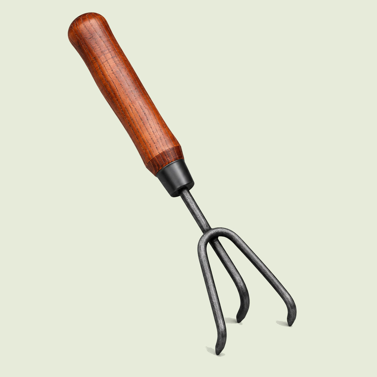 Three-Prong Hand Cultivator on a soft green background