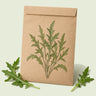 Kraft seed packet illustrated with Wild Rocket Arugula, with fresh Wild Rocket Arugula beside it